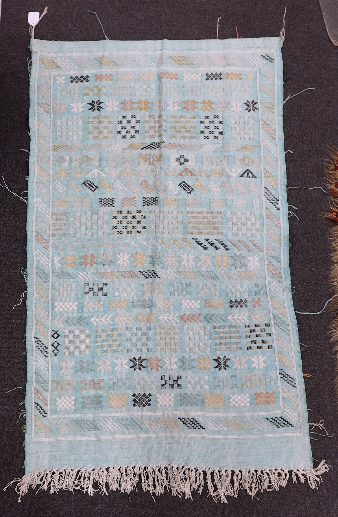 A turquoise rug, possibly Scandinavian